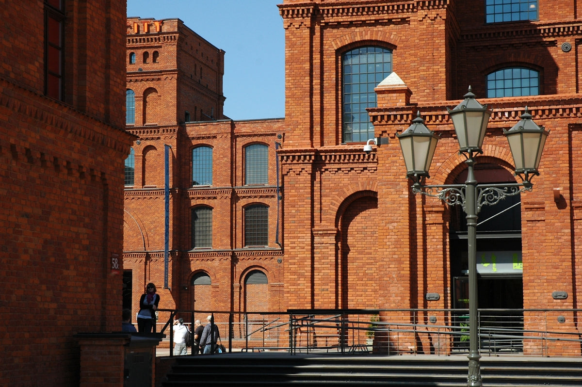 people walking on sidewalk near brown concrete building during daytime