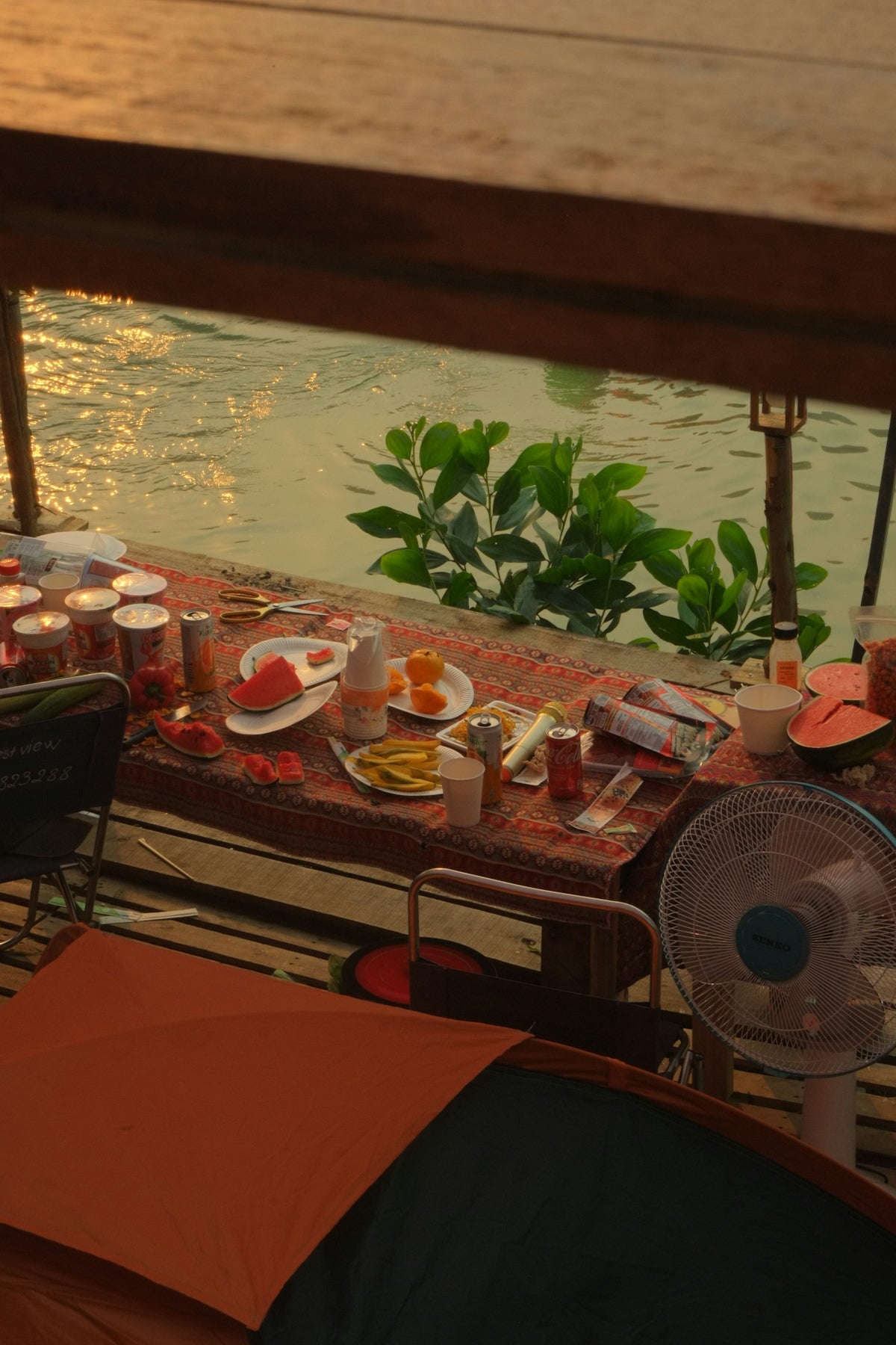 a table that has food on it next to a body of water
